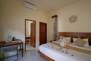 a bedroom with a large bed with a desk and a bed sidx sidx at KU Villas in Kuta Lombok +58 photos