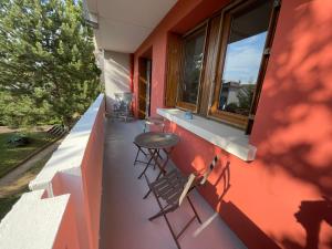 a balcony with chairs and a table on the side of a house at Le Relais des Cyclamens Bron in Bron