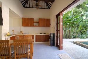 a kitchen and dining room with a table and chairs at KU Villas in Kuta Lombok