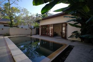 a house with a swimming pool in front of it at KU Villas in Kuta Lombok