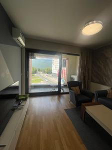 a living room with a couch and a large window at ilidza sky river 2 in Sarajevo