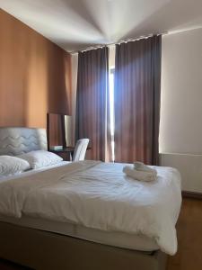 a bedroom with a large white bed and a window at ilidza sky river 2 in Sarajevo