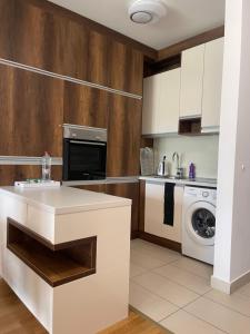 a kitchen with white cabinets and a washer and dryer at ilidza sky river 2 in Sarajevo