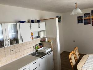 a kitchen with white cabinets and a sink at Smještaj Klekovača in Drvar