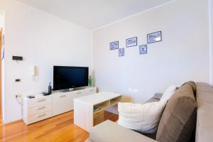 a living room with a couch and a tv at Miren apartma Ankaran SP - Peaceful Apartment Ankaran SP in Ankaran