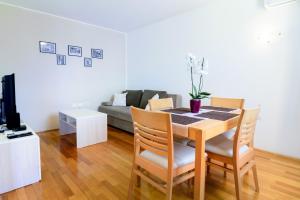 a living room with a table and chairs and a couch at Miren apartma Ankaran SP - Peaceful Apartment Ankaran SP in Ankaran
