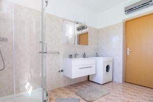 a bathroom with a sink and a washing machine at Miren apartma Ankaran SP - Peaceful Apartment Ankaran SP in Ankaran +19 photos
