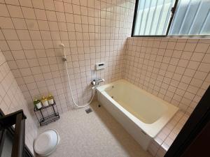 a bathroom with a tub and a toilet at Asobico焼津 in Yaizu +56 photos