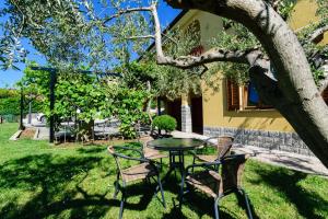 a table and chairs under a tree in a yard at Miren apartma Ankaran SP - Peaceful Apartment Ankaran SP in Ankaran