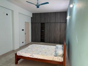 a bedroom with a bed and a ceiling fan at Chandran Apartments in Vellore