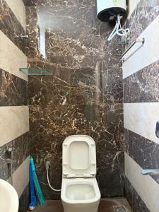 a bathroom with a toilet and a sink at Chandran Apartments in Vellore +8 photos