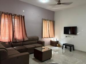 a living room with a couch and a flat screen tv at Chandran Apartments in Vellore