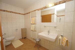 a white bathroom with a sink and a toilet at Haus Tauernseitn in Schladming +21 photos