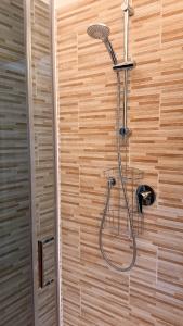 a shower with a shower head on a wooden wall at ECO - Villa Giulia in Dormelletto +96 photos