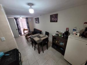 a living room with a table and a refrigerator at Liz in Matehuala