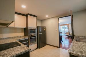 a kitchen with a stainless steel refrigerator at The Mercer Sukhumvit 4 in Bangkok