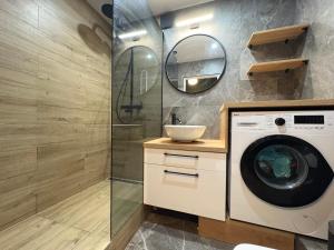 ein Badezimmer mit Waschmaschine und Spiegel in der Unterkunft CUTE FLAT centrum in Suwałki