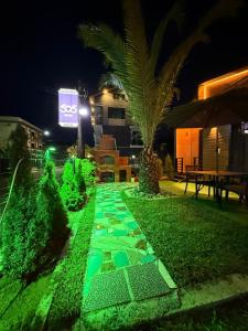 a walkway with green lighting in a yard at night at Cottage 505 in Ureki +2 photos
