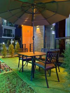 a wooden table and chairs under an umbrella at Cottage 505 in Ureki