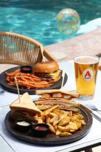 a table with two plates of food and a sandwich and french fries at Nikiforos Village in Hanioti