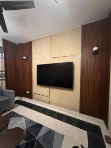 a living room with a flat screen tv on a wall at ضيوف الخريف in Salalah
