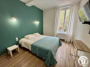 a bedroom with a bed and a green wall at La prade in Saint-Ferriol +21 photos