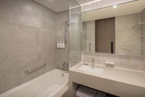 a bathroom with a sink and a tub and a mirror at Hyatt Place Seoul Pangyo in Seongnam