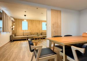 a living room with a table and chairs and a couch at Triangle 2nd in Beppu