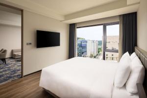 a hotel room with a bed and a large window at Hyatt Place Seoul Pangyo in Seongnam