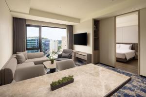 a hotel room with a king bed and a living room at Hyatt Place Seoul Pangyo in Seongnam