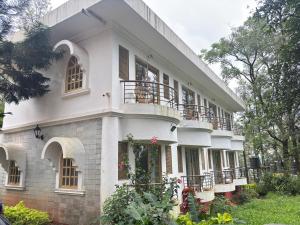 a large white building with balconies on it at Nature Trinity House in Panchgani
