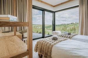 two beds in a room with a large window at Matygowa Osada in Gliczarów Górny