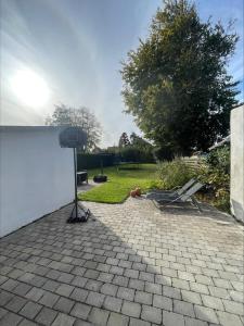 a light on a brick patio with a white wall at Hyggely in Nakskov