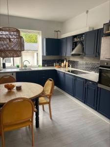 a kitchen with blue cabinets and a table and chairs at Hyggely in Nakskov