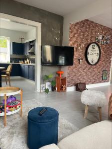a living room with a clock on a brick wall at Hyggely in Nakskov