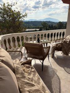 a patio with a table and chairs on a balcony at Happyfield in Lixouri +6 photos