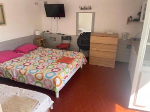 a bedroom with a bed and a dresser with a mirror at La farigoulette in Rayol-Canadel-sur-Mer