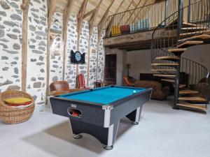a pool table in a room with a staircase at Le Domaine Eugenie in Cassuéjouls