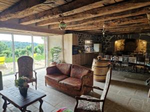 a living room with a leather couch and a table at Le Domaine Eugenie in Cassuéjouls