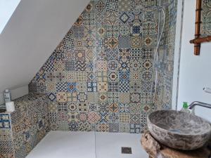 a bathroom with a mosaic wall with a sink at Le Domaine Eugenie in Cassuéjouls +54 photos