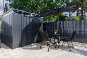 a black fence with a table and an umbrella at Gemütliches Ferienhaus in Kell am Traumpfad nahe Maria Laach in Andernach
