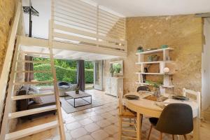 a room with a loft bed and a table and chairs at Gite Beauséjour in Gaugeac