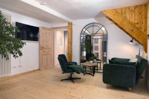 a living room with green chairs and a table at Gemütliches Ferienhaus in Kell am Traumpfad nahe Maria Laach in Andernach