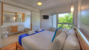 a bedroom with a large bed and a bathroom at Maggies Beachfront Apartment 5 in Horseshoe Bay