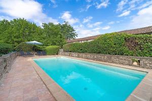 a swimming pool in a yard with an umbrella at Gite Beauséjour in Gaugeac