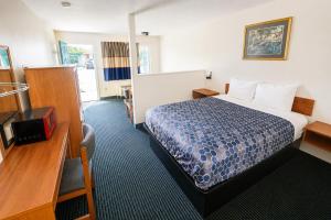 a hotel room with a bed and a desk at Relax Inn Dover Near Speedway in Dover