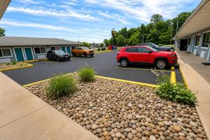 a red car parked in a parking lot at Relax Inn Dover Near Speedway in Dover