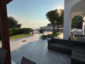 a patio with a view of the ocean from a building at VILLA CLARA ISCHIA piscina riscaldata e idromassaggio in Lacco Ameno