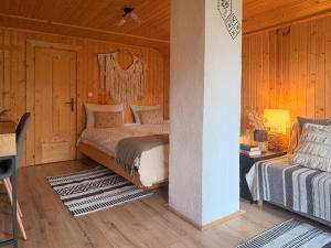 a bedroom with a bed in a wooden room at Cuib din Fagaras in Avrig