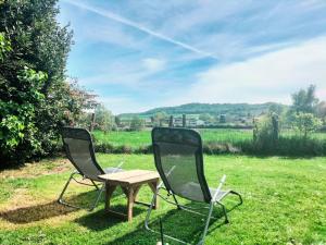 two chairs and a table in the grass at Cottage de Vardes in Neufmarché